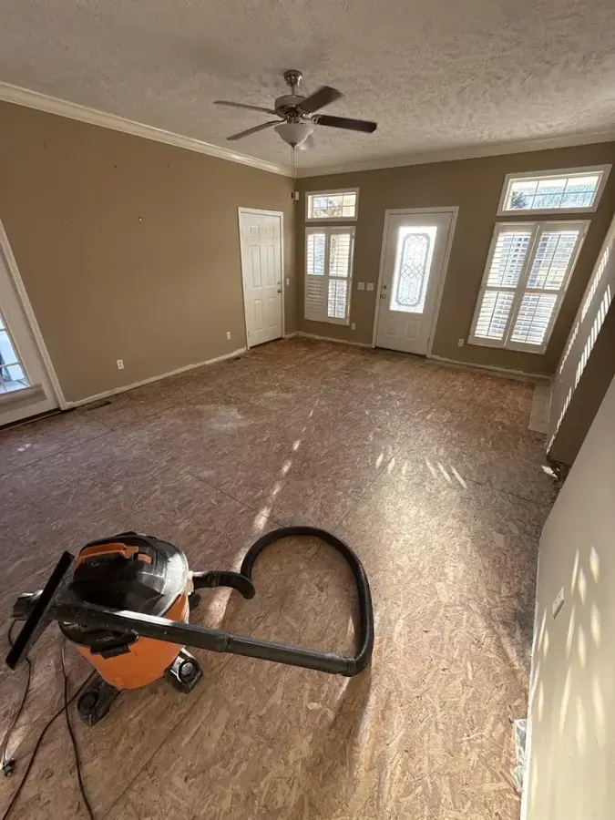 Wet vacuum on a bare subfloor in a room stripped after a leak