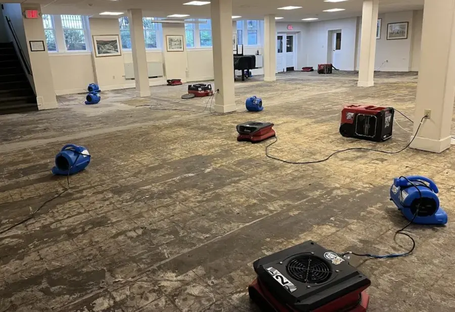 Air movers and dehumidifiers drying a large room after water damage in Maryville, TN